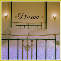 bedroom wall lettering above metal framed headboard in bedroom